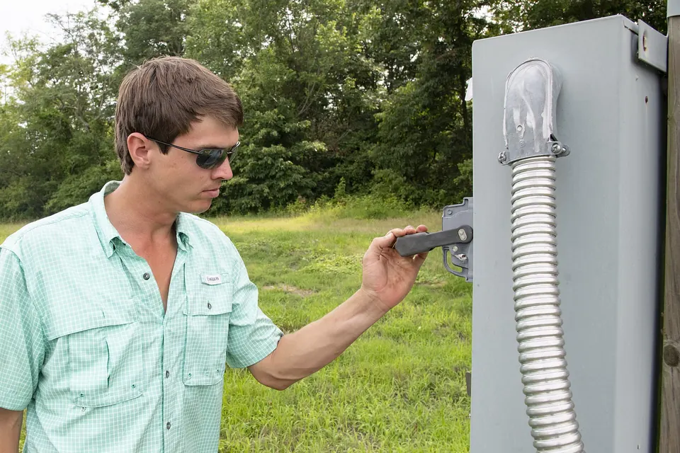 Technicien ouvrant l'armoire électrique d'une station de pompage