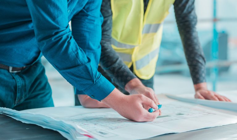 ouvriers-verifiant-le-plan-architectural-d-un-projet-1